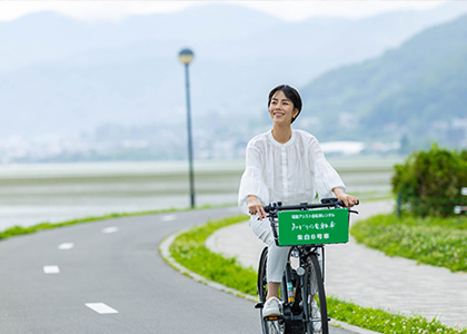 春の諏訪湖でサイクリングを楽しむ女性